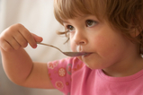 Image of child eating with spoon
