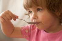 Image of child eating with a spoon